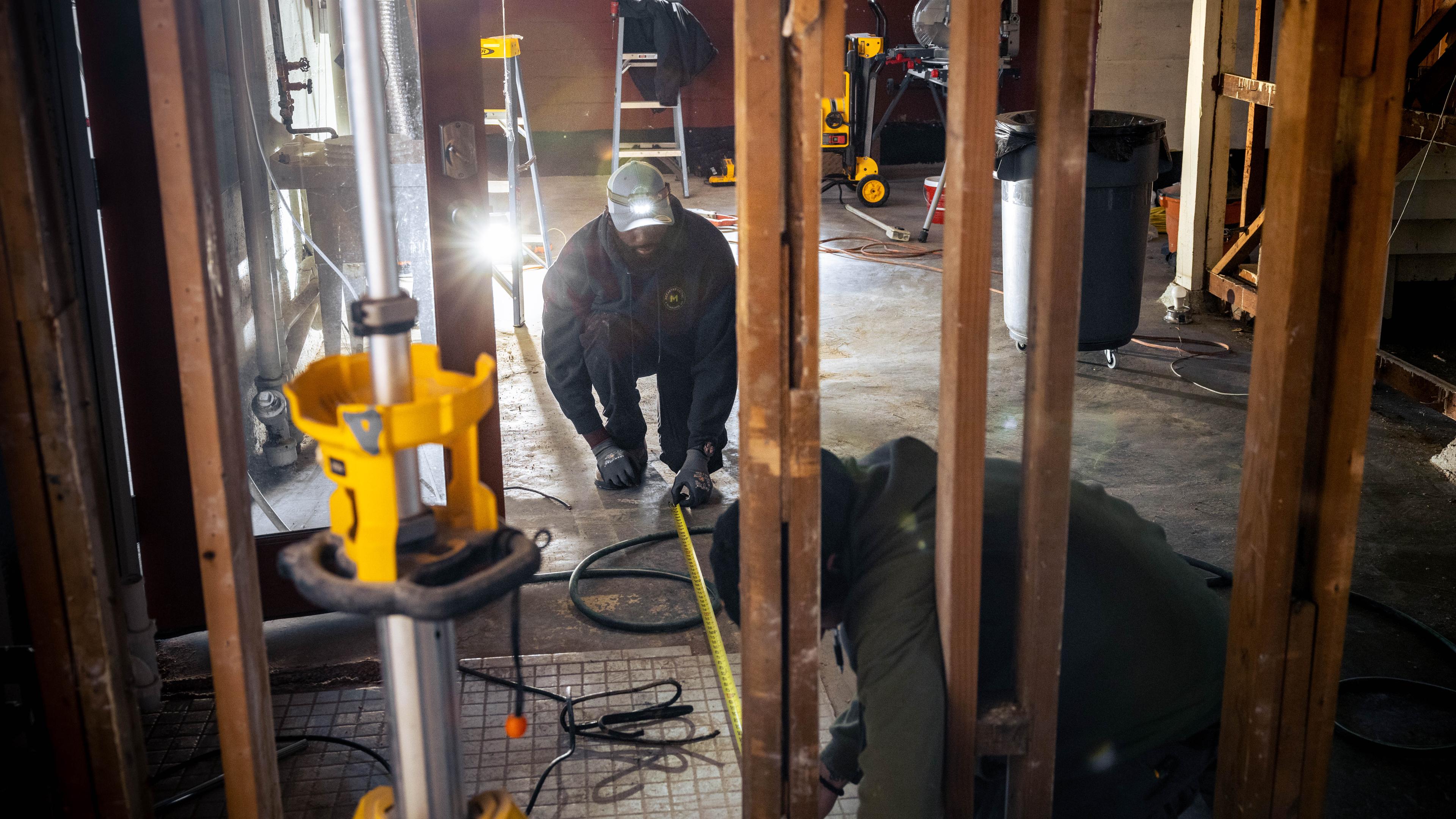 Worker installing insulation in an attic remodel